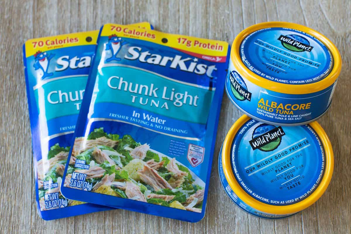 Two packets of StarKist chunk tuna in water next to two cans of tuna.