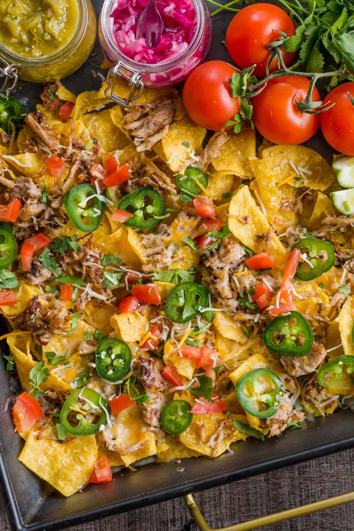 A tray of nachos with vibrant veggies on top