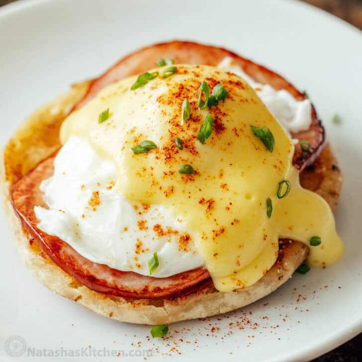 Eggs Benedict with Hollandaise sauce served on a white plate