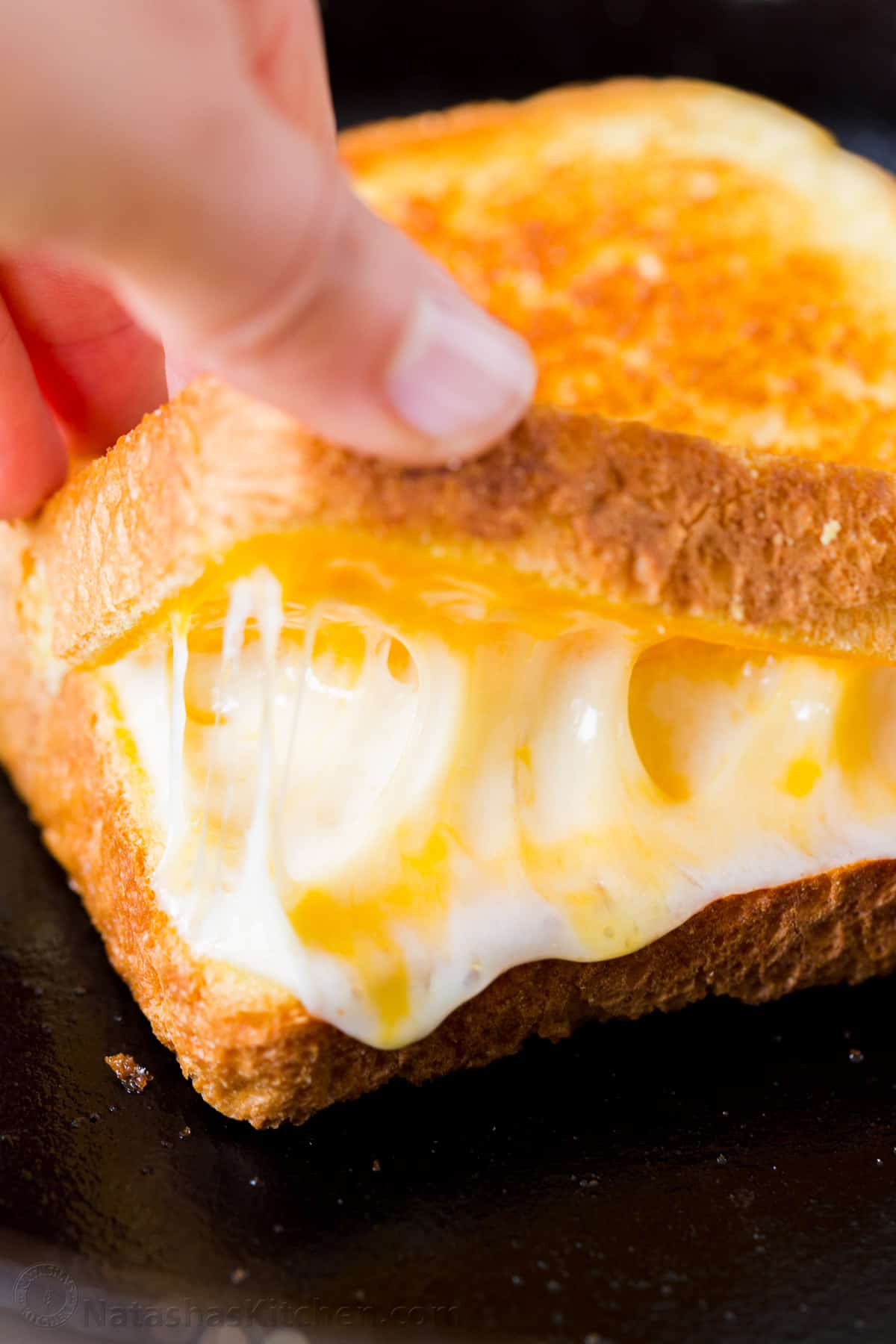 Melty cheese inside of a grilled cheese sandwich