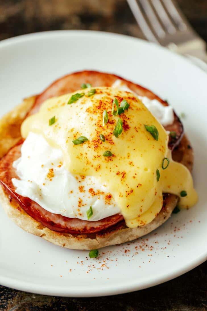 Eggs Benedict on a plate topped with hollandaise