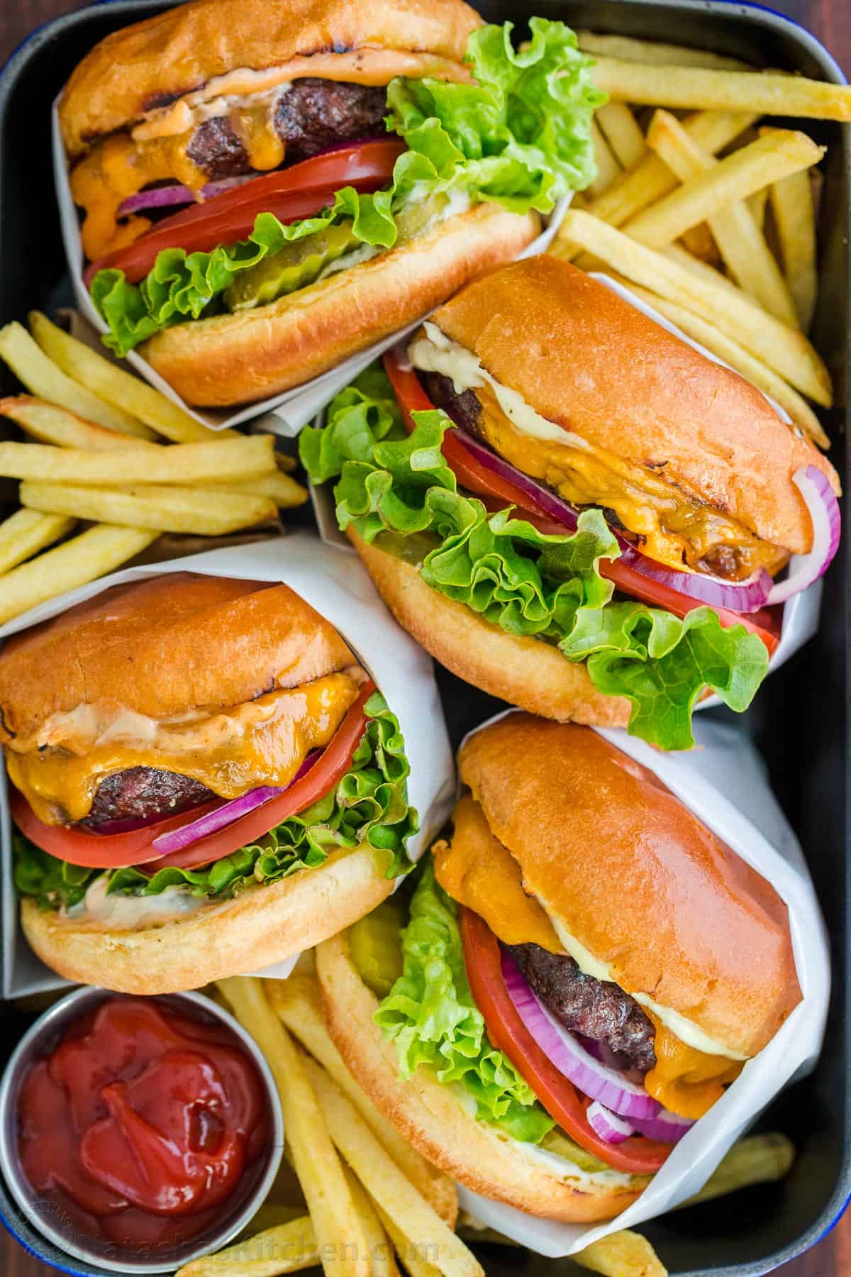 Hamburgers in a serving tray with fries